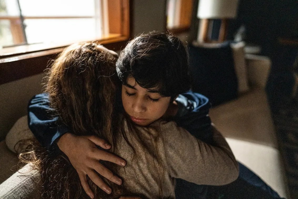 Two people embracing at a community gathering