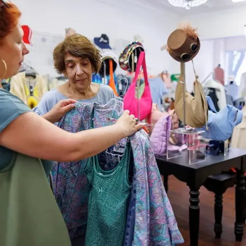 Shopper holding up a lavender top at Sister's Closet
